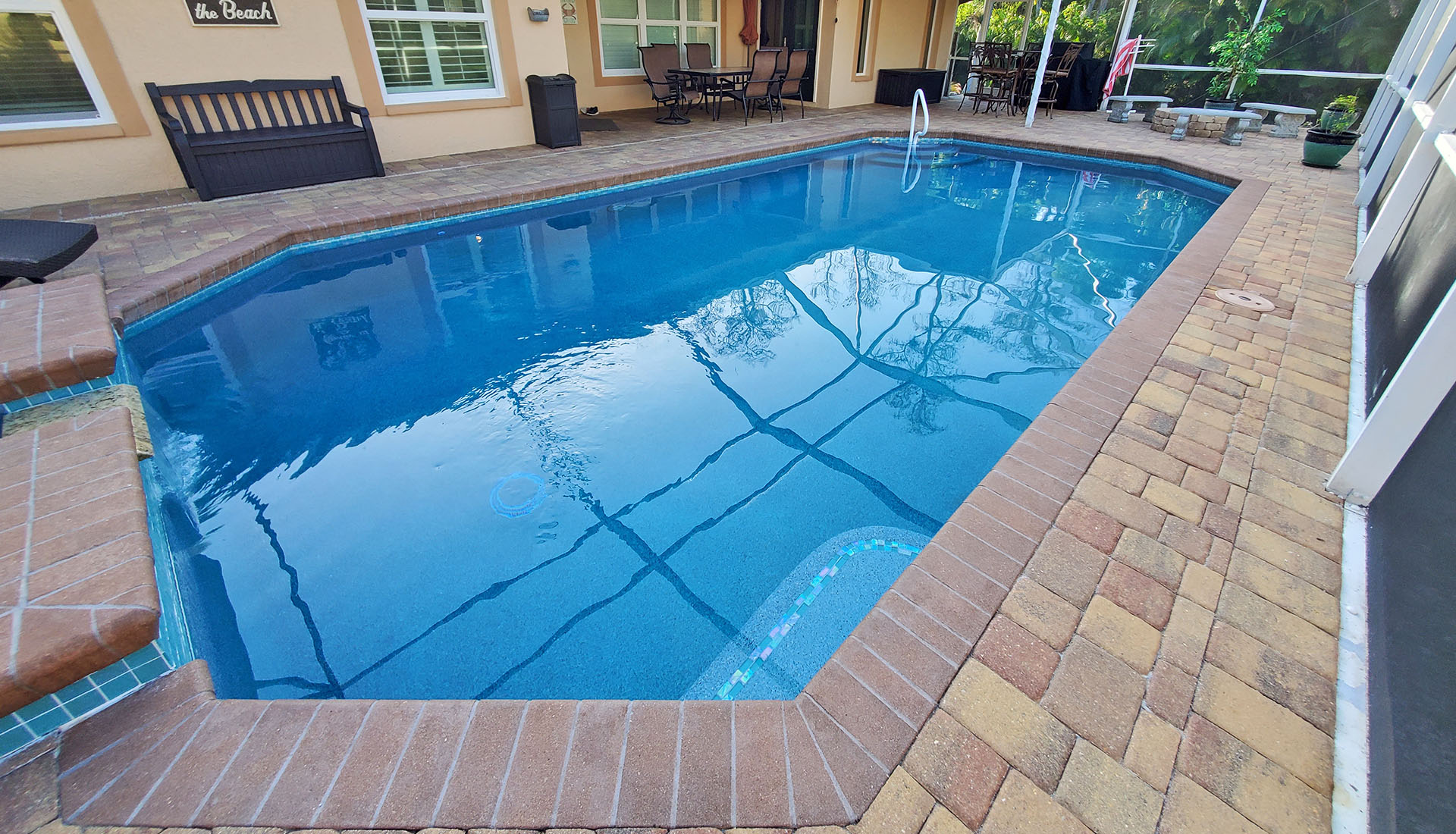 Cool blue pool with Cement Paver decking by Pool and Deck Concepts