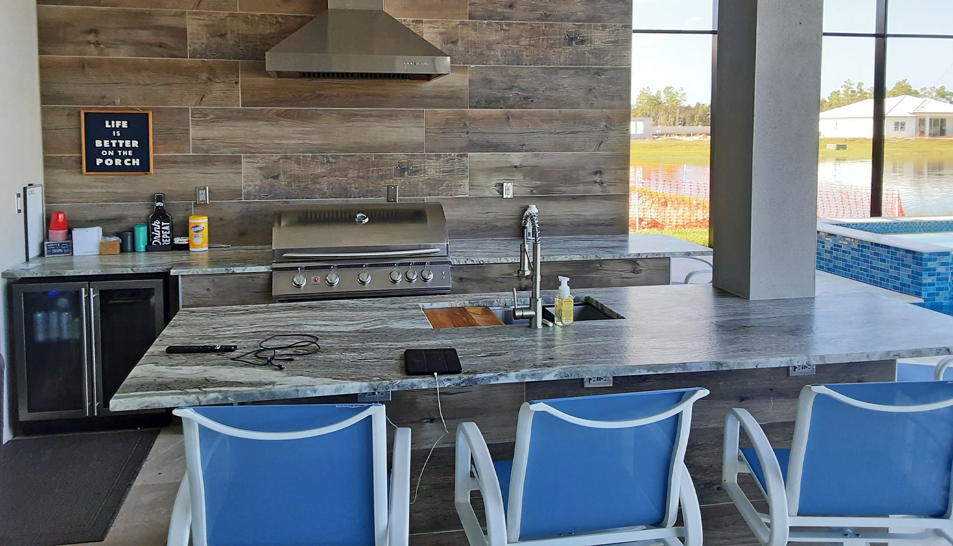 Custom Outdoor Kitchen design with island, grill and fridge by Pool and Deck Concepts